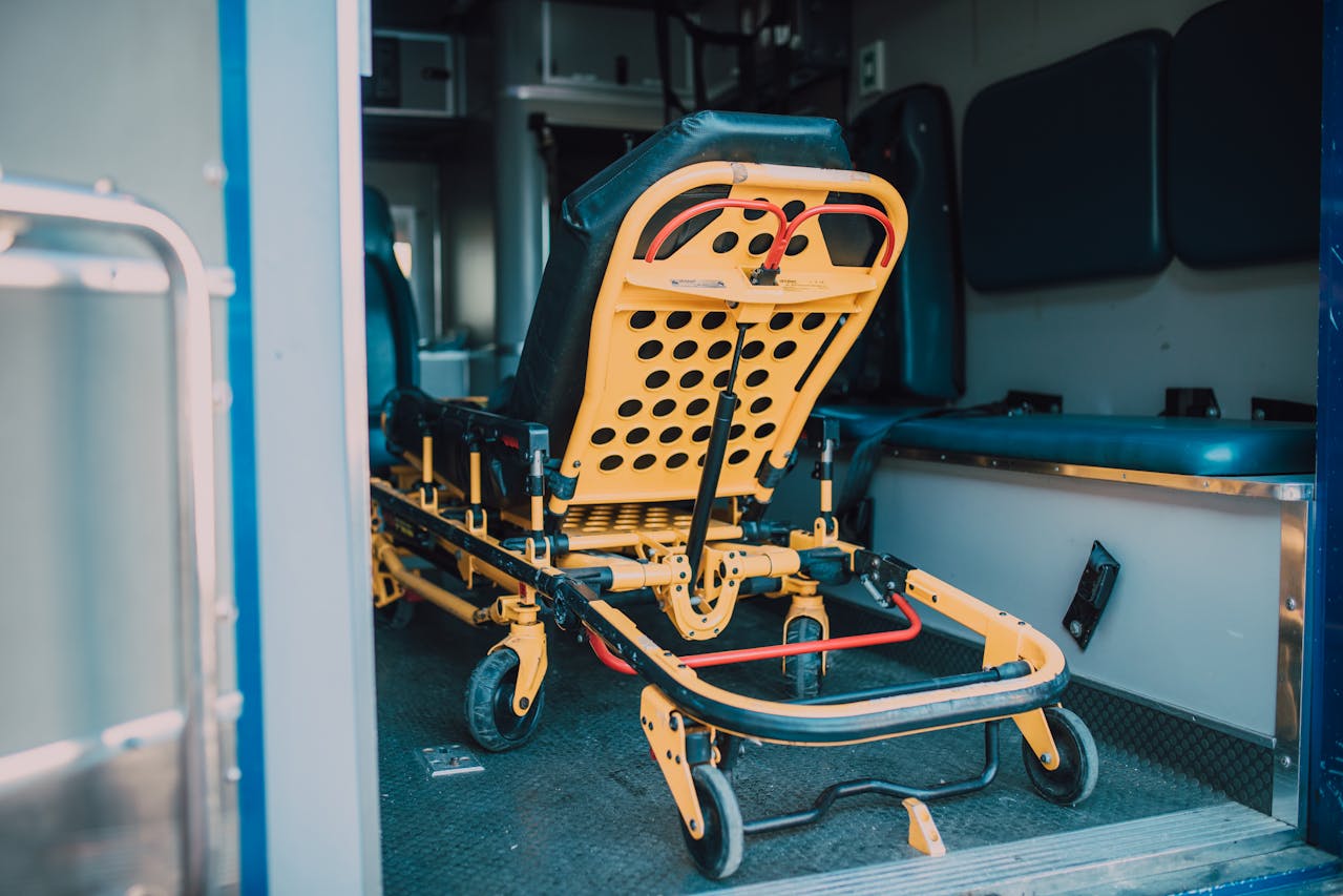 Puste, żółto-czarne nosze stojące w ambulansie — symbol realnej pomocy, jaką zapewniły lokalne zbiórki w czasie pandemii, zamieniając symboliczne gesty w konkretne wsparcie medyczne.